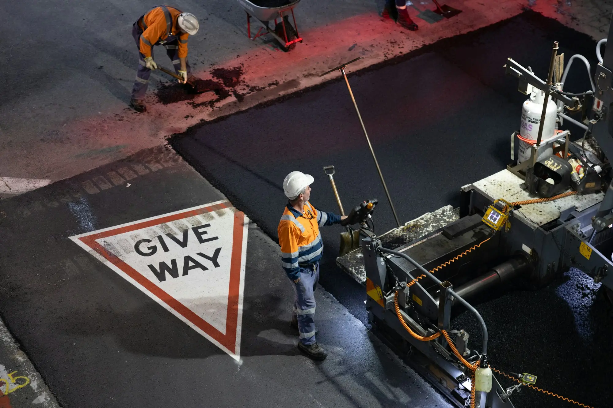 Builder in hard hat reviewing plans on a Brisbane residential construction site