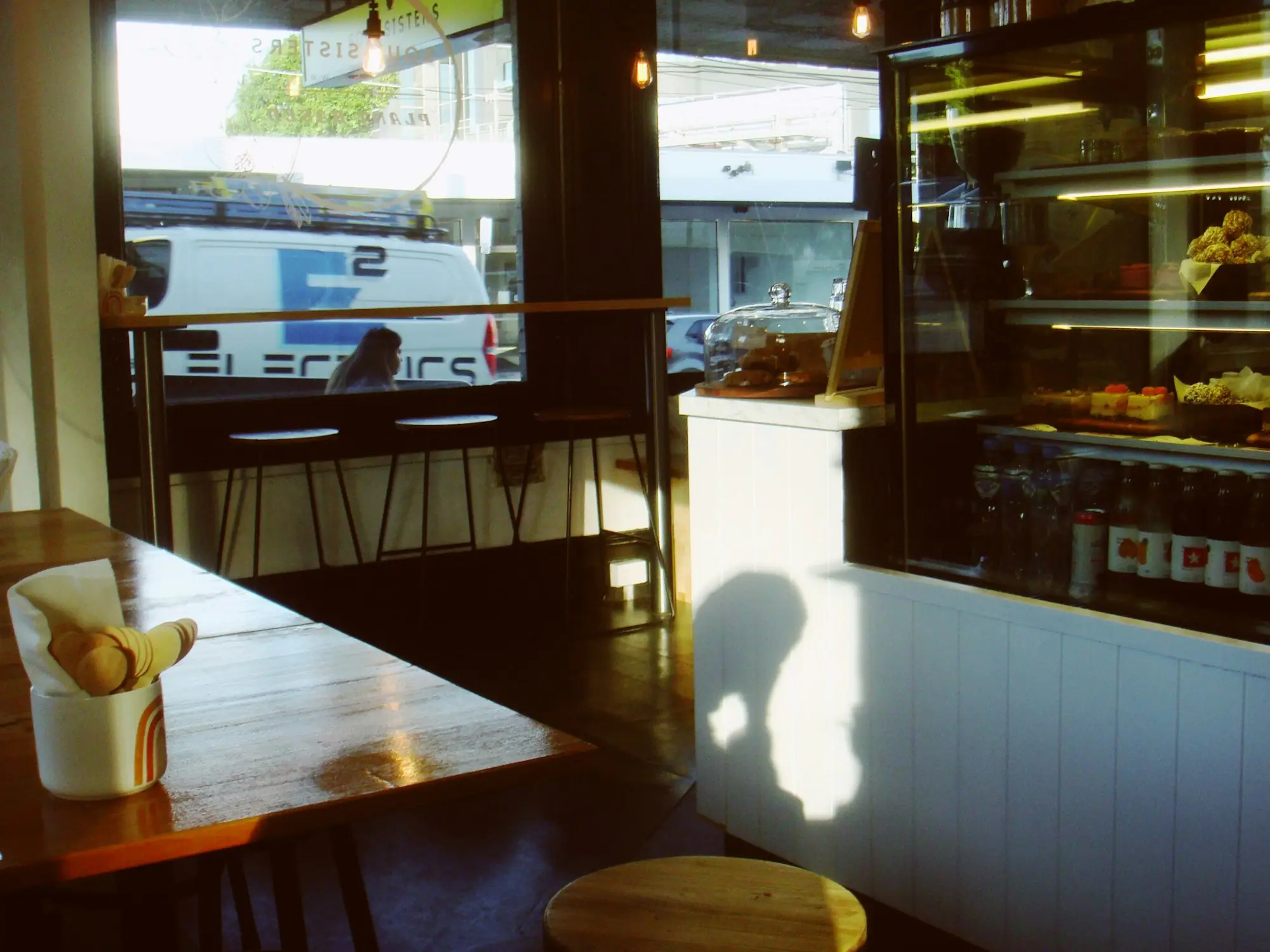 Cafe owner pulling an espresso shot behind the counter of a busy inner Melbourne cafe