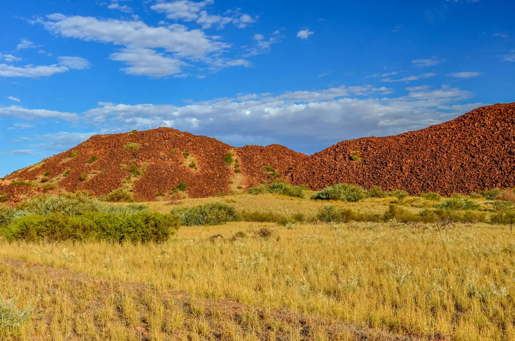 Mine-site ute with flag on a red Pilbara dirt road